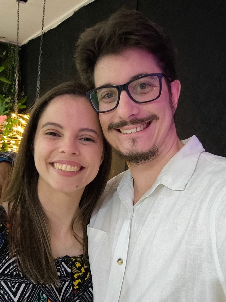 Caroline e Lucas sorrindo juntos numa festa